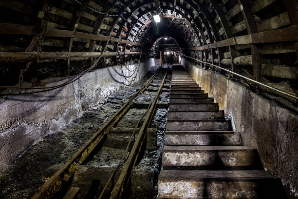 istock Coal mine underground corridor with stairs and railroad track 673664084
