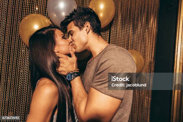Romantic Young Couple Kissing In The Night Club Stock Photo - Download Image Now - Kissing, Couple - Relationship, Party - Social Event