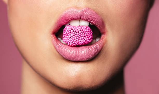 istock Beautiful pink lips with a piece of candy 673674470