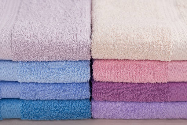 stapel von bunten badetücher auf hellem hintergrund. - softness textile pink terry cloth stock-fotos und bilder