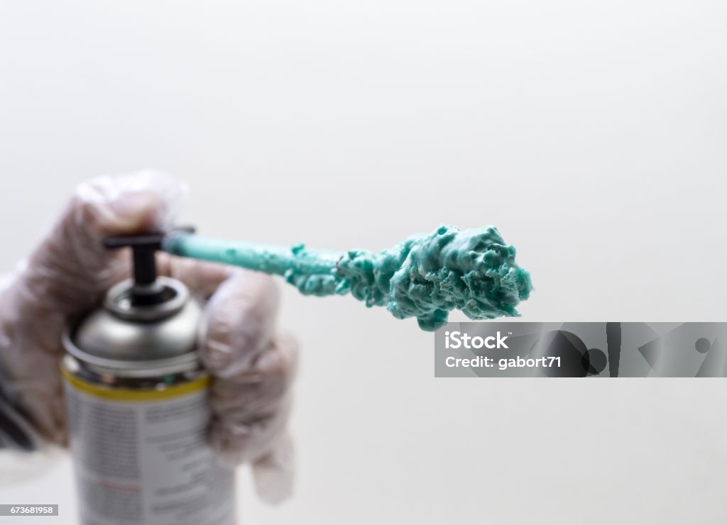 polyurethane expanding foam Worker hand holding polyurethane expanding foam glue gun. Polyurethane Stock Photo