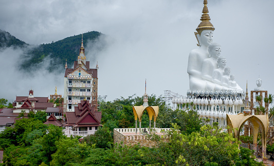 High in the mountains of Phitsanulok Thailand is Five Buddhas Statue, the signature statue of Wat Pra Sorn Kaew, or “Temple on the Glass Cliff”. An innovative artechural design with liberal use of ceramic and glass mosaics on a wonderful ridge top location combine for a must-see temple.