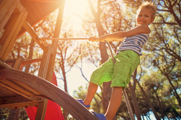 istock Little boy climbing in pine forest playground 673687662