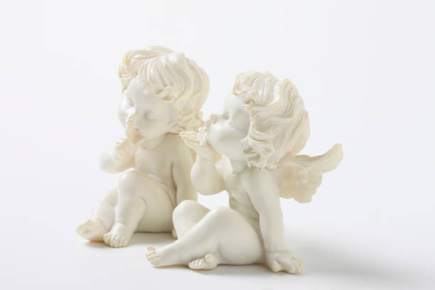 A little angel figurine on an old wooden stairway. The angel is reading a book and requests silence.