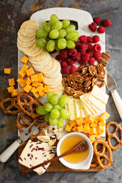 istock Cheese and snacks platter with honey and fresh fruit 673704388