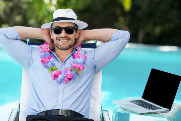 Smart man wearing garland while relaxing in sun lounger near pool