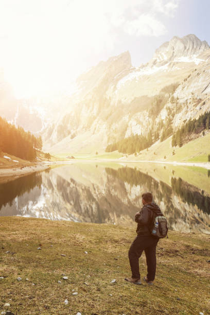istock back of hiker with backpack who watching to the lake 673713836