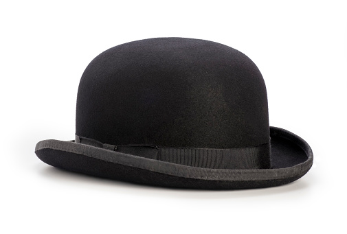 This is a photograph taken in the studio of a black bowler hat sitting on a white background. There is a drop shadow included with this file and there are no people in the shot