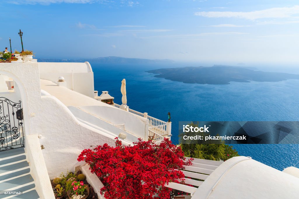 Una Vista De Caldera Y Típicas Flores Rojas En La Terraza De Una Casa En El Pueblo De Firostefani Isla De Santorini Grecia Foto de stock y más banco de imágenes de Una Vista De Caldera Y Típicas Flores Rojas En La Terraza De Una Casa En El Pueblo De Firostefani Isla De Santorini Grecia Foto de stock y más banco de imágenes de