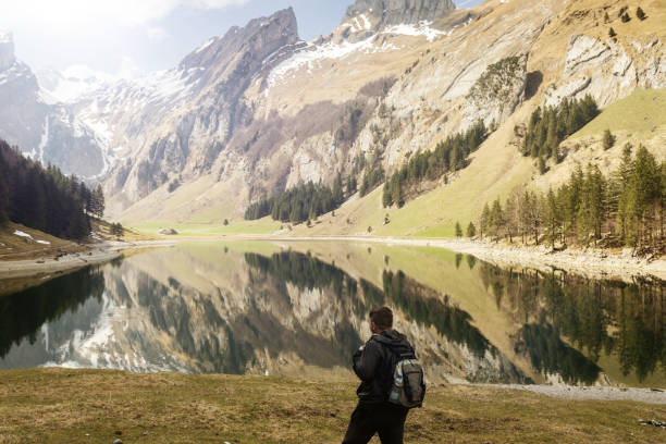 istock back of hiker with backpack who watching to the lake 673719910