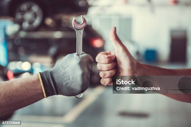 Handsome Auto Service Workers Stock Photo - Download Image Now - Car, Repairing, Auto Repair Shop