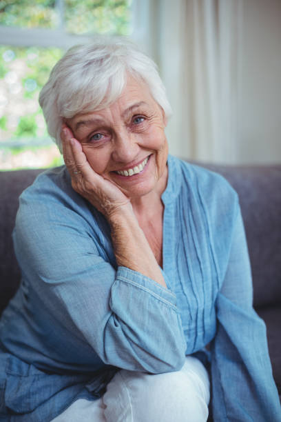 istock Happy senior woman sitting on sofa 673726766