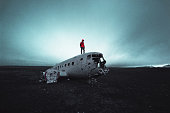 man on top of a plane wreck in iceland
