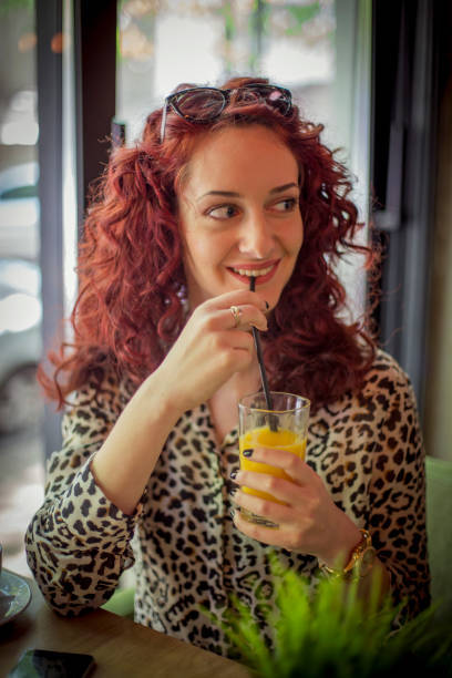 istock Cute young woman drinks orange juice 673735294