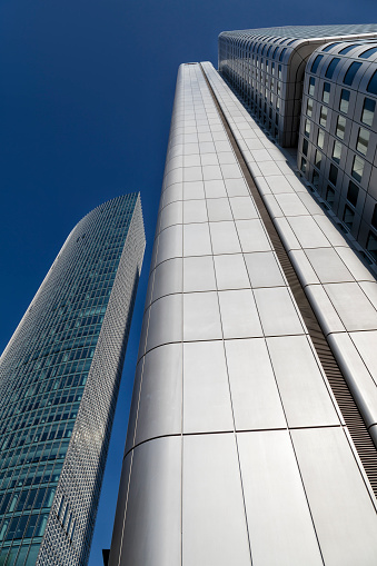Modern corporate buildings, office buildings in financial district, low angle view with blue sky, Frankfurt, Germany.