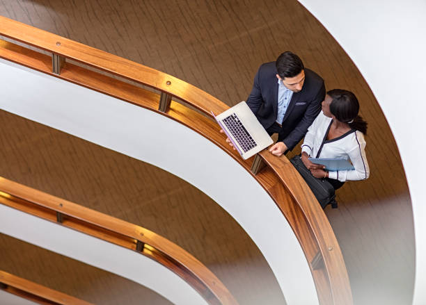 istock Two Business People Standing in the office building  and Using Laptop 673751344