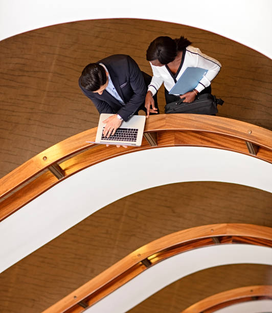 istock Two Business People Standing in the office building  and Using Laptop 673751392
