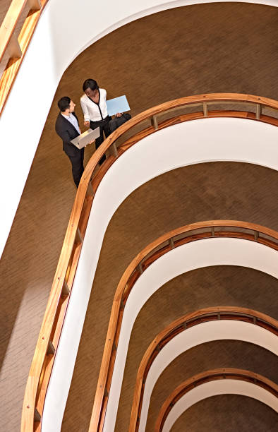 istock Two Business People Standing in the office building  and Using Laptop 673752998