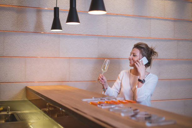 istock Classy woman drinking wine and using phone 673757154