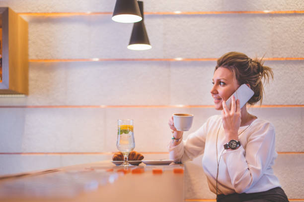 istock Happy young woman using mobile phone at a cafe 673757180
