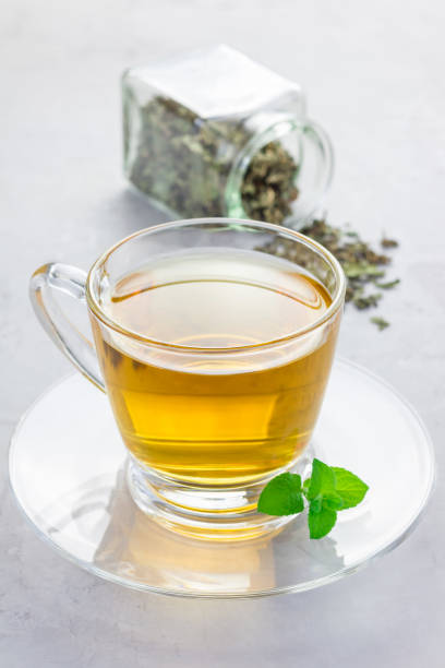 istock Herbal mint tea in a glass cup with dry peppermint tea on background, vertical 673766044
