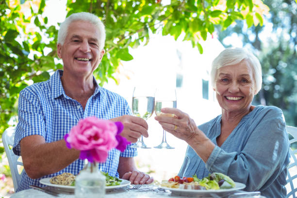 istock Smiling senior couple toasting white wine 673768760