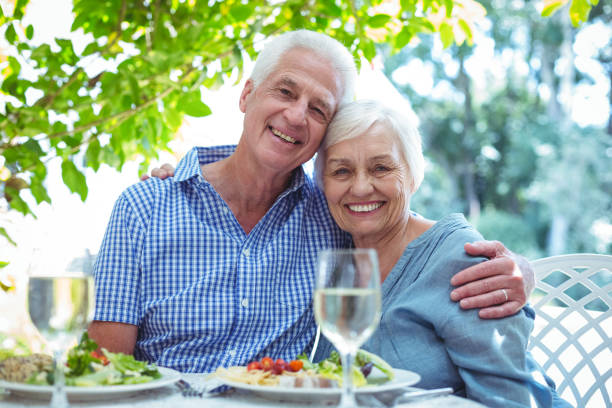 istock Happy retired couple with arm around at table 673771486