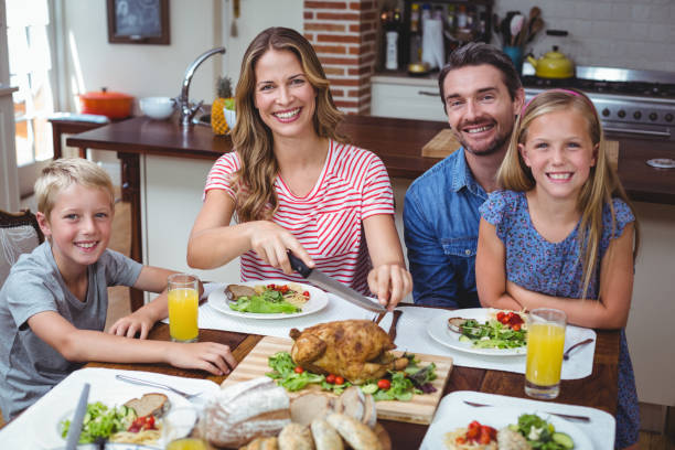 istock Smiling family sitting at dining table 673797880