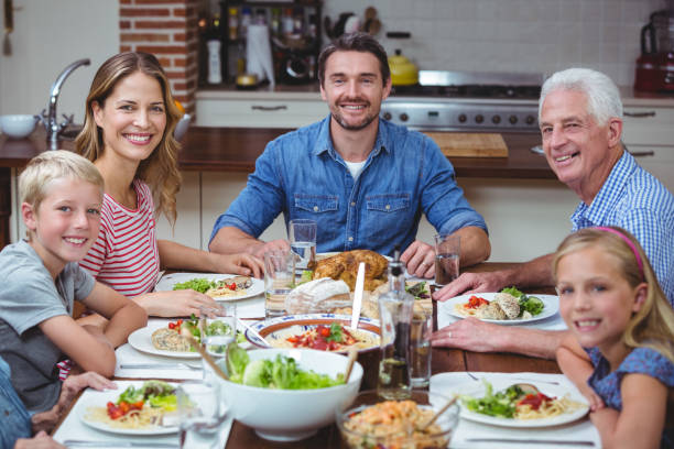 istock Smiling multi generation family sitting at dining table 673798138