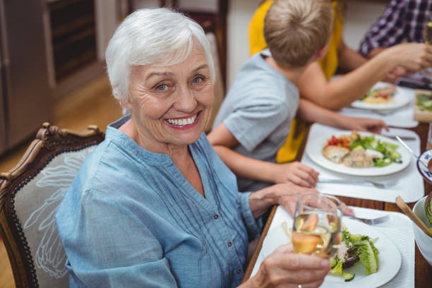 istock Portrait of smiling granny sitting at dining table 673803976