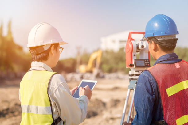 ingénieur de construction avec tablette intelligente et contremaître ouvrier vérifiant le chantier de construction - employé de domaine photos et images de collection