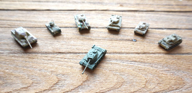 istock old toy tanks on wooden background. 673819402