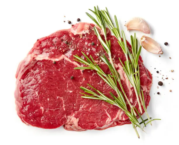 fresh raw rib eye steak isolated on white background, top view