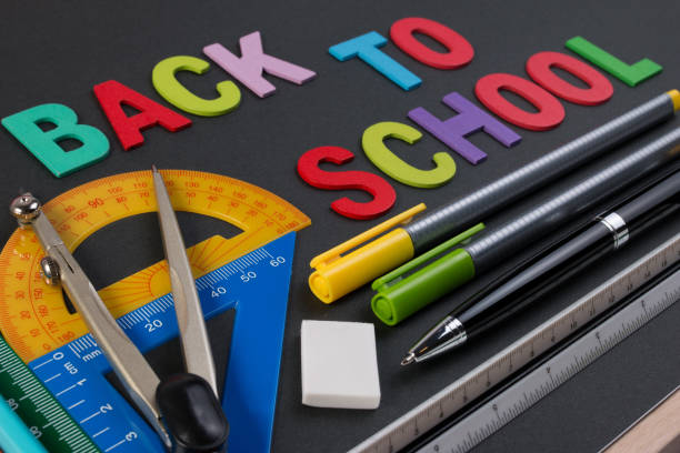 istock Mathematical instruments over the corner of black paper with text back to school. 673823072