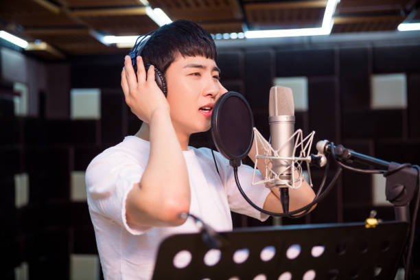 Close up of a young singer recording a track in a studio stock photo