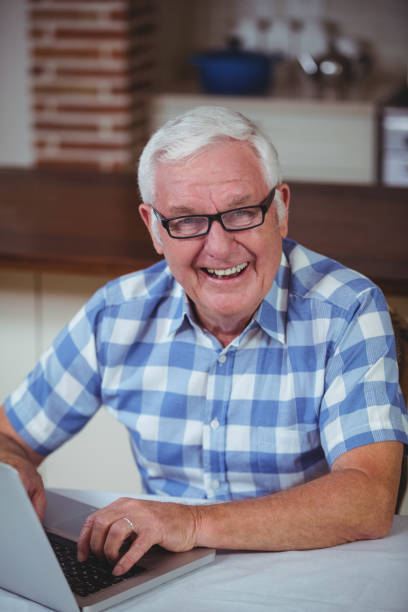istock Portrait of happy retired man using laptop 673829648