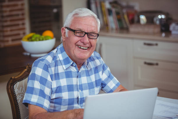 istock Portrait of smiling retired man using laptop 673829830