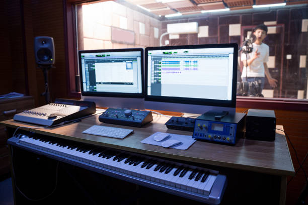 istock Young male singer singing in studio,technician in foreground 673830502