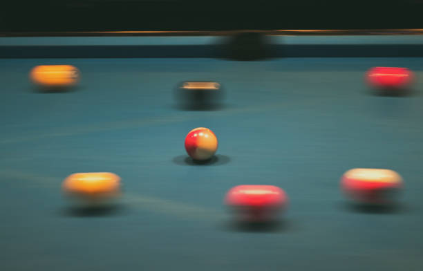 istock Group of multi-colored pool balls on a table in blurred motion. 673836144