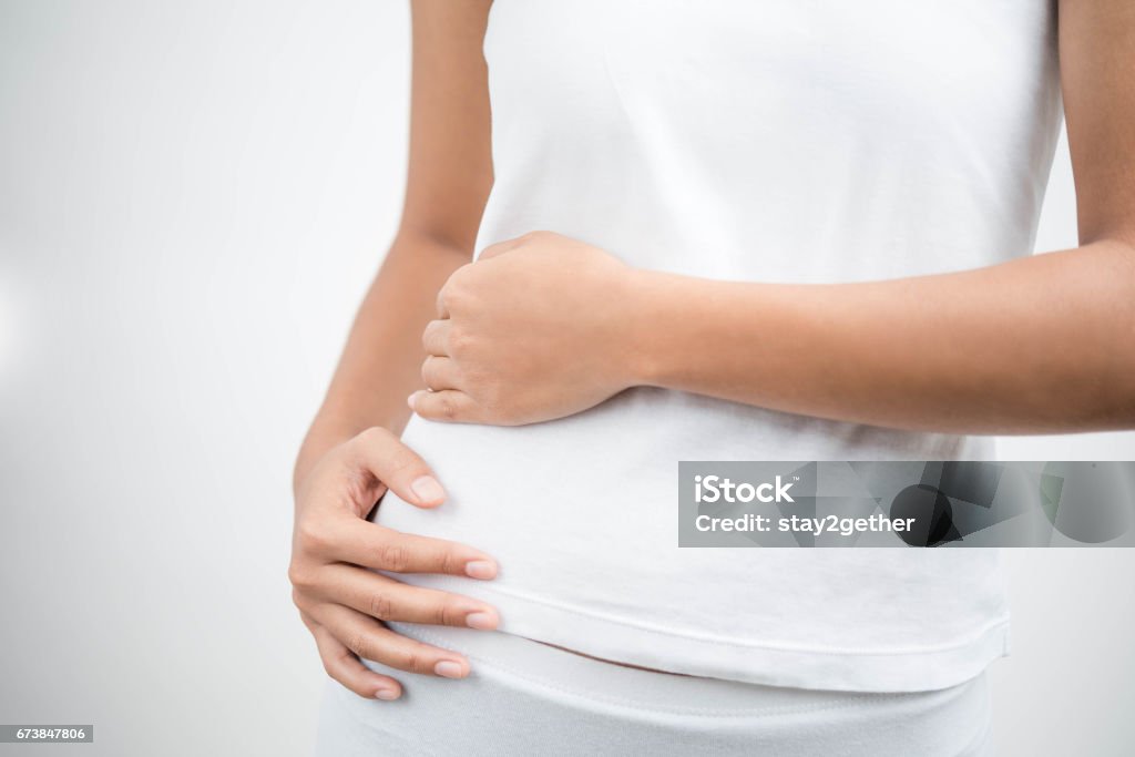 Young female touching her right side in pain . Kidney inflammation and therapy. Medicine and health care concept. white background Hip - Body Part Stock Photo