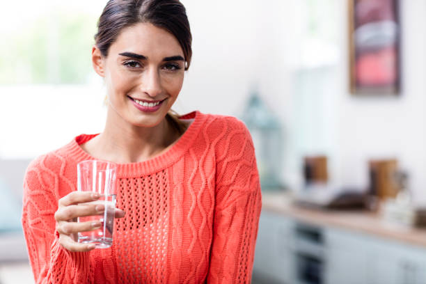 istock Happy young woman holding drinking glass 673848132