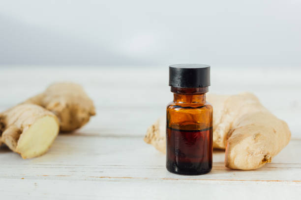 istock Ginger essential oil in glass bottle with ginger root behind. 673851874