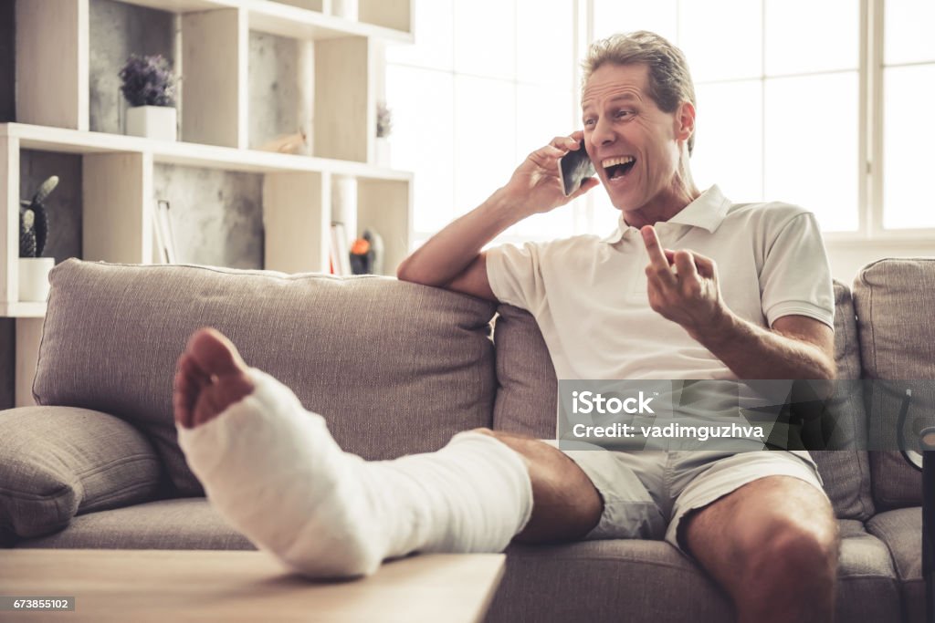 Homme avec la jambe cassée - Photo de Béquille libre de droits