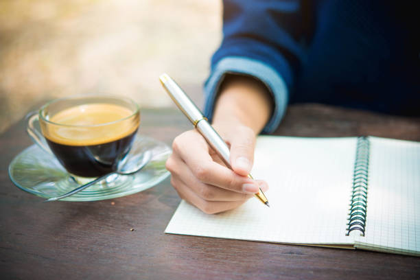 istock women writing and key board coffee on wooden table 673861532