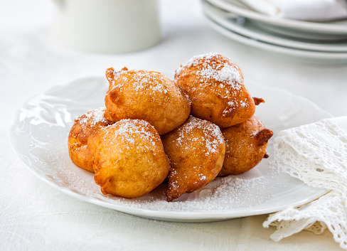 Sweet homemade beignets covered with powdered sugar.