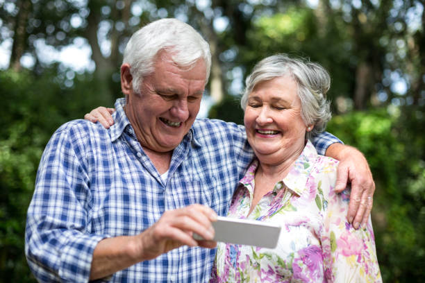 istock Senior couple holding smart phone in back yard 673865998