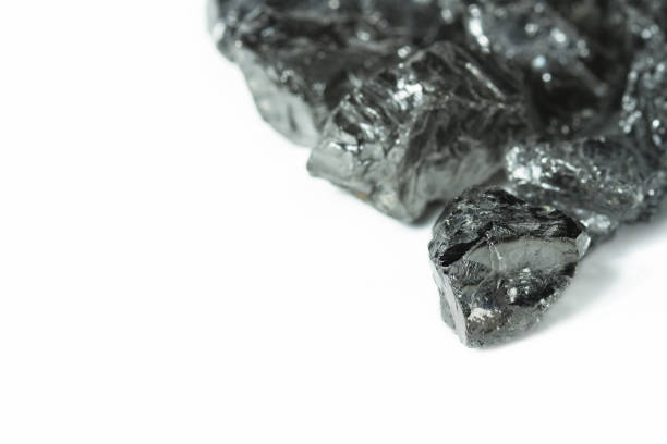 istock Raw coal nuggets on white background with blured foreground. Nuggets of raw coal isolated on white background 673867036