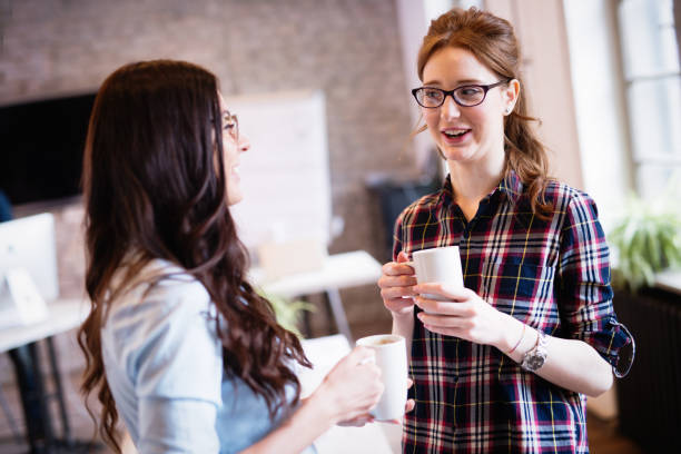 istock Female employees having coffee break in modern office 673869552