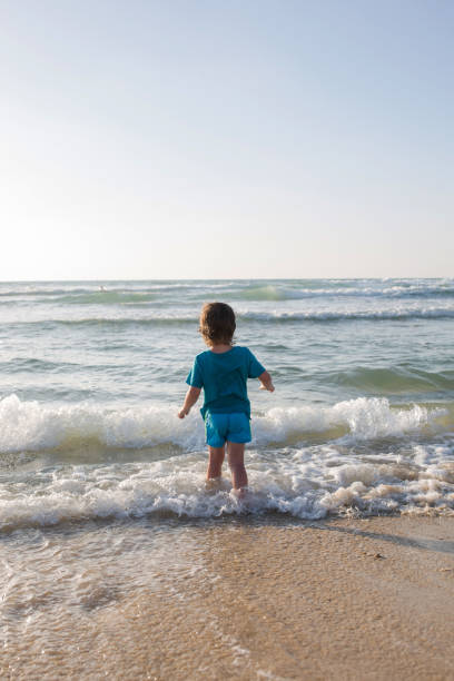 istock Back view of child at the beach. 673870306