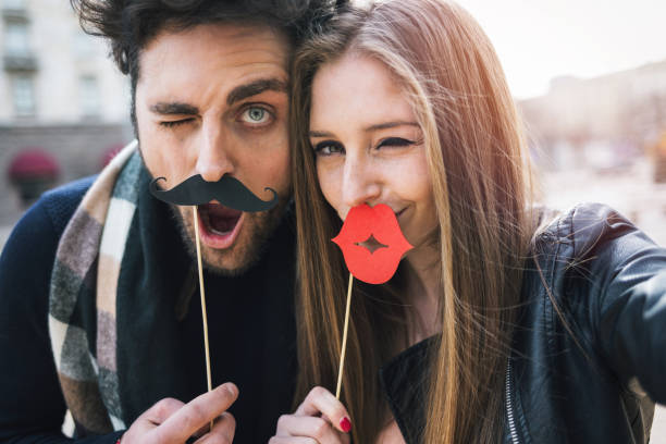 Funny selfie Couple making selfies with paper mustaches and lips young man wink stock pictures, royalty-free photos & images